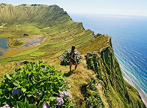 Vue sur le Caldeirão de Corvo aux Açores avec falaises verdoyantes et océan Atlantique
