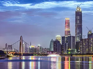 Silhouette der nächtlichen Skyline von Guangzhou, gespiegelt im Wasser, mit hohen Wolkenkratzern.