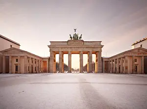 Brandenburger Tor in Berlin während der Winterzeit, mit Schnee bedecktem Platz und Morgenlicht.