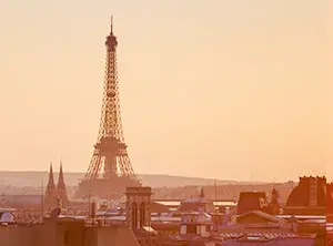Vue sur la tour Eiffel au lever du soleil au-dessus des toits de Paris.