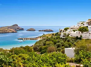 Küste auf Rhodos mit türkisblauem Meer, kleinen Buchten und weissen Häusern am Hang
