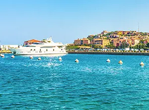 Port de Porto Cervo en Sardaigne avec yacht blanc et maisons colorées