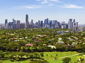 Blick auf die Skyline von Manila mit umgebendem Grün und Golfplätzen.