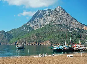 Plage en Turquie avec bateaux d’excursion et montagne en arrière-plan