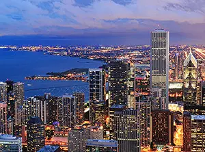 Skyline von Chicago bei Abenddämmerung mit Hochhäusern, Lichtern und Blick auf den Lake Michigan