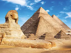 Sphinx et pyramides de Gizeh dans le désert égyptien sous un ciel bleu