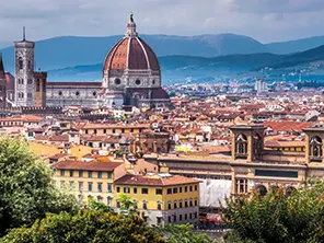 Vue rapprochée du Duomo de Florence et de son dôme majestueux, dominant les toits de la ville avec le campanile de Giotto en arrière-plan.