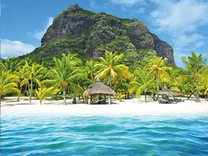 Plage de sable blanc bordée de palmiers avec le Morne Brabant et un lagon turquoise