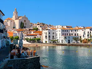 Blick auf Cadaqués an der Costa Brava mit weißen Häusern, Kirche und Bucht am Meer