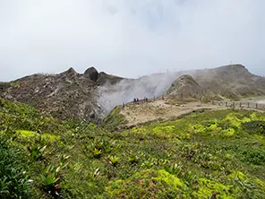 Vulkan La Soufrière auf Guadeloupe mit grüner Vegetation und aufsteigendem Dampf