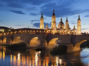 Basilika Nuestra Señora del Pilar und Steinbrücke in Saragossa bei Abendlicht