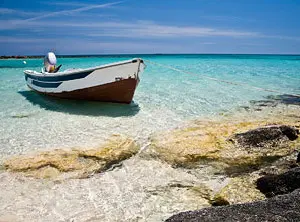 Kleines Boot im klaren, flachen Wasser an einem Strand auf Kreta
